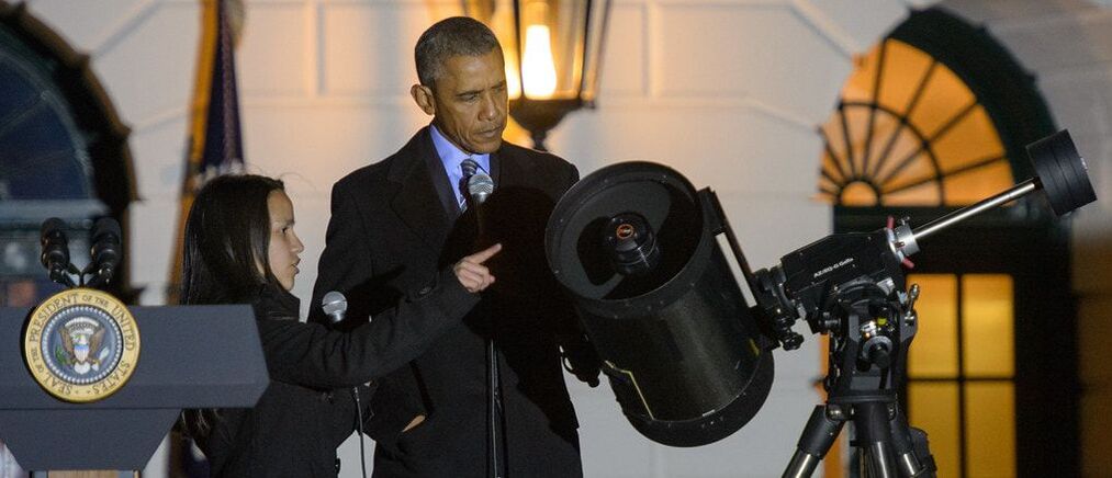 Student and President Obama looking at telescope